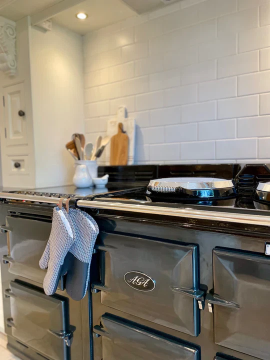 Keeping your aga cooker clean: picture of a pewter aga cooker front with a pair of oven gloves