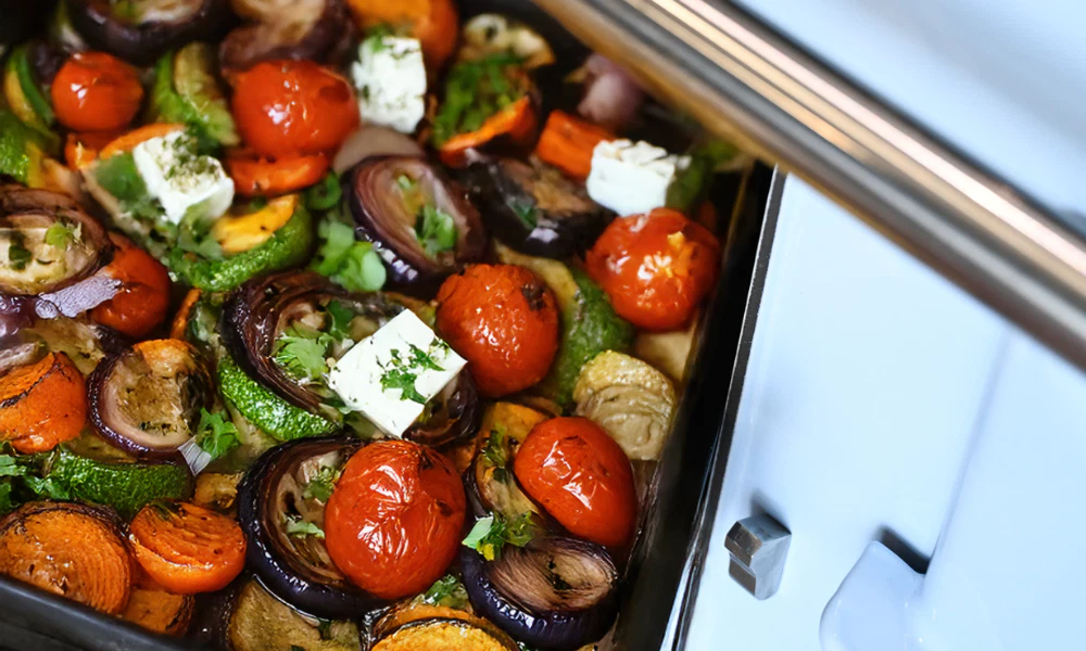 Aga cooking: picture of a tray full of roasted veg coming out of the aga roasting oven